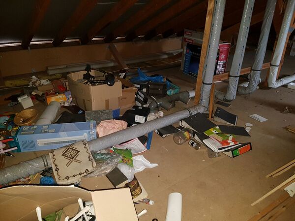 Dachboden mit Kartons, Aktenordnern, Isolierrohren und verschiedenen Haushaltsgegenständen.